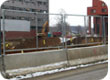 Temporary fence panels mounted to Jersey barrier